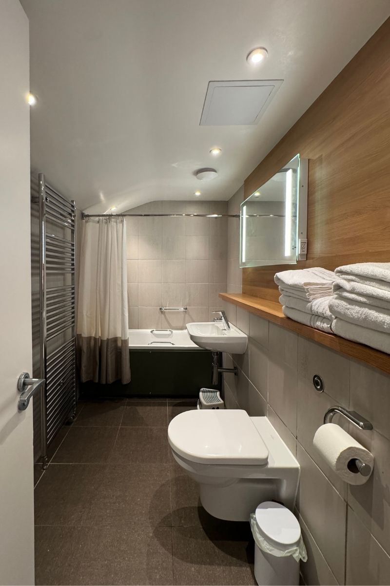 Bathroom with a bath and shower over in a two-bedroom Woodland Lodge at Center Parcs Whinfell Forest