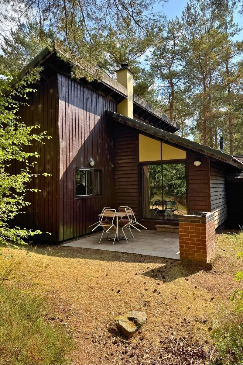 Outside patio area of a two-bedroom Woodland Lodge at Center Parcs Whinfell Forest with garden furniture and grill