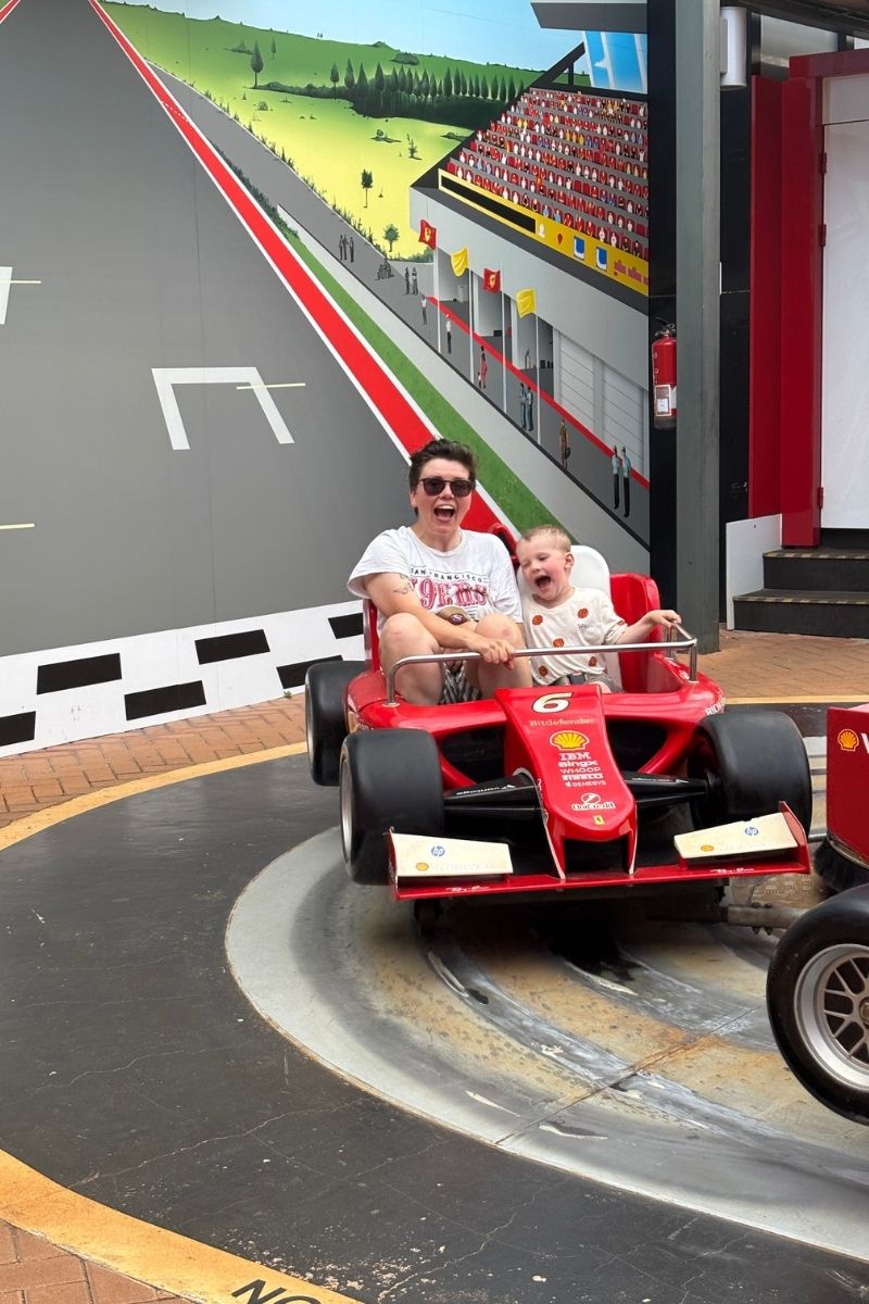Cora and her son Oliver in a Ferrari car at Ferrari World inside PortAventura, Salou